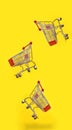 Many shopping carts are flying with yellow background Royalty Free Stock Photo