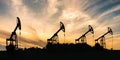 Many silhouettes of drilling oil rigs at sunset