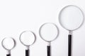 Many sizes of magnifying glass on white table,top view Royalty Free Stock Photo