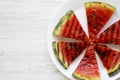 Many slices of fresh ripe grilled watermelon on a white round plate over white wooden background, from above. Healthy summer fruit Royalty Free Stock Photo