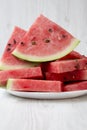 Many slices of ripe juicy watermelon on a round white plate, closeup