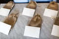 Many small brown bags of fabric and white cards