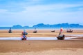Many small fishing boats on sand beach during low tide with cloudy blue sky Royalty Free Stock Photo