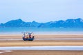 Many small fishing boats on sand Beach during low tide with cloudy blue sky Royalty Free Stock Photo