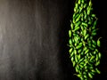 Many small green chillies isolated on black background