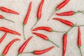 Many small hot red chili peppers close-up throw in random order on a natural sackcloth textile background. Vegetables