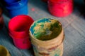 many small paint jars with different colors on a wooden surface