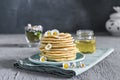 Many small pancakes with honey or syrup. Delicious traditional breakfast. Spring flowers as food styling in photography. Gray Royalty Free Stock Photo