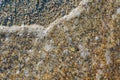 Many small pebbles background on seashore. Motion transparent wa Royalty Free Stock Photo