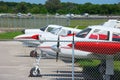 Many small planes parked and lined up on the tarmac at an airport on a sunny afternoon Royalty Free Stock Photo