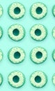 Many small plastic donuts lies on a pastel colorful background. Flat lay minimal pattern. Top view Royalty Free Stock Photo