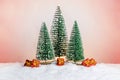 Many small presents under Christmas tree in miniature forest on snow