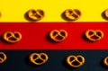 Many small pretzels on a background of the German flag colors