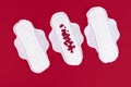 Many small red hearts, symbol of the menstrual cycle, on a feminine sanitary napkin. Feminine hygiene products during the