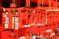 Many small Torii Gate hanging on red wooden hanger at Fushimi Inanari Shrine. People write blessings on amulets and prayed