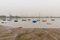 Many small wooden fishing boats anchored and sunk in the low waters of the Odiel River estuary in Huelva under a hazy sky Royalty Free Stock Photo