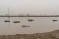 Many small wooden fishing boats anchored and sunk in the low waters of the Odiel River estuary in Huelva under a hazy sky Royalty Free Stock Photo