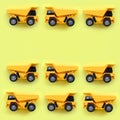 Many small yellow toy trucks on texture background of fashion pastel yellow color paper in minimal concept