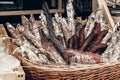 many smoked sausages and salami in wooden basket on table at street food festival. catering outdoors, open kitchen, summer picnic