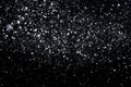 Many snowflakes in blur on black background. Snowfall layer for winter photo