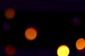 Many soft orange and yellow blurry bokeh light on dark purple tone background in Christmas and New Year festival day Royalty Free Stock Photo