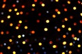 Many soft orange, yellow, red and blue blurry bokeh light on dark tone background in Christmas and New Year festival day Royalty Free Stock Photo