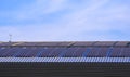 Many solar panels on curved steel roof of industrial building against blue sky Royalty Free Stock Photo