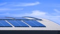 Many solar panels on top of curved steel roof of industrial building against blue sky Royalty Free Stock Photo