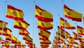 Many Spain flags in rows waving against clear blue sky Royalty Free Stock Photo