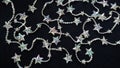 Many sparkling, shimmering star chains for Christmas, on black background