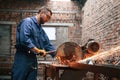 Many of the sparks. Welding the metal. Factory worker in blue uniform is indoors