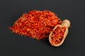 Many spicy saffron spice in the whole background with a wooden spice spatula