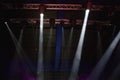 many spotlights shining on stage above