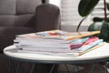 Many stacked magazines on table in room