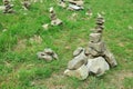 Many stacked stones on green grass outdoors, space for text Royalty Free Stock Photo