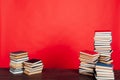 Many stacks of educational books for learning the preparation for exams on a red background