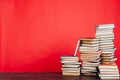 Many stacks of educational books for learning the preparation for exams on a red background