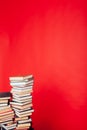 Many stacks of educational books for learning the preparation for exams on a red background