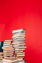 Many stacks of educational books to study in the college library on a red background