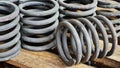 Many steel springs of shock absorbers on wooden palete. Spare parts of heavy industrial machinery