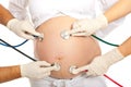 Many stethoscopes on pregnant belly