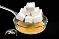 Many sugar cubes on a spoon above hot coffee Royalty Free Stock Photo