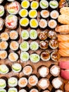 Many sushi and rolls on wooden table