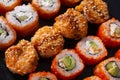 Many sushi , set of baked with eel , cheese , Japanese rolls Philadelphia with salmon, California with caviar, on a black