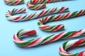 Many sweet Christmas candy canes on light blue background, closeup Royalty Free Stock Photo