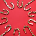 Many sweet Christmas candy canes on red background, flat lay. Space for text Royalty Free Stock Photo