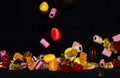Many sweet and colourful candies are falling down to the table
