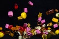 Many sweet and colourful candies are falling down to the table