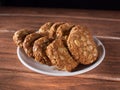 many sweet oatmeal cookies on a white plate on a wooden board Royalty Free Stock Photo