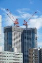 Many tall buildings under construction and cranes under a blue sky Royalty Free Stock Photo